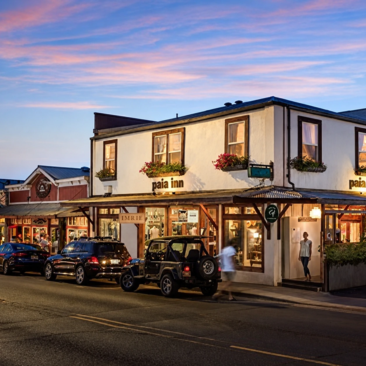 A mixed-use building with streetfront shops at dusk