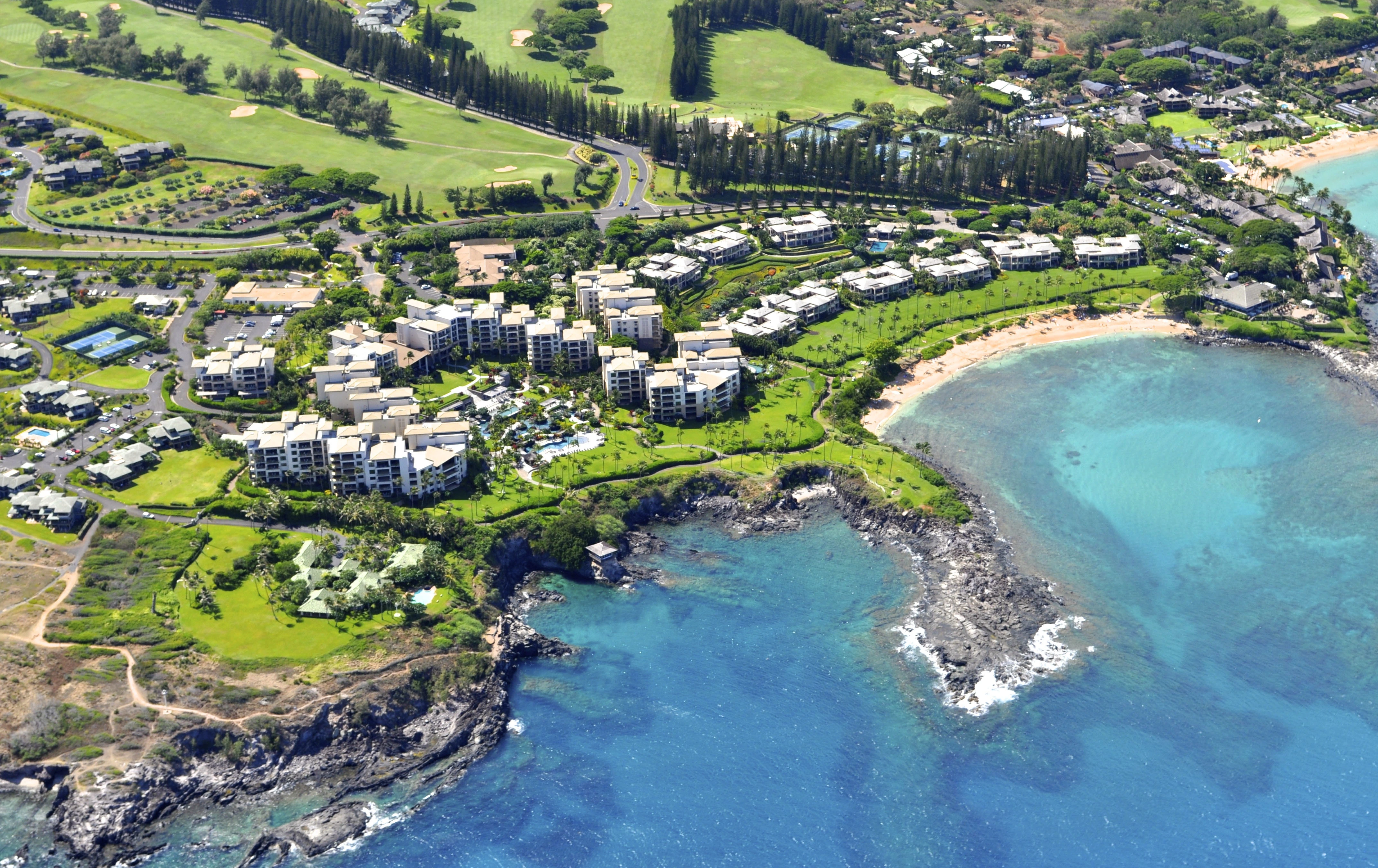 Aerial view of a coastal resort with beaches, hotel buildings and golf courses